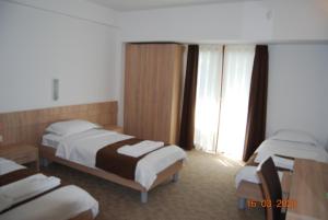 a hotel room with two beds and a window at Kompleks Negorski Banji in Gevgelija