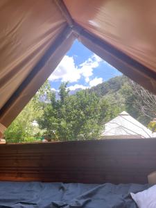 a window in a bedroom with a view of a mountain at Le bivouac-tente chez Camille in Veynes