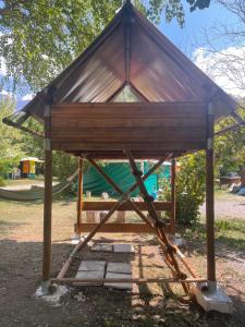a wooden shelter with a hammock in a park at Camping chez Camille in Veynes