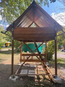 a wooden shelter with a hammock in a park at Le bivouac-tente chez Camille in Veynes
