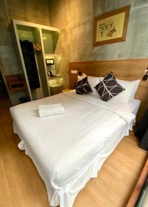 1 cama blanca grande con 2 almohadas en Chaos Boutique Hotel Kuala Lumpur, en Kuala Lumpur