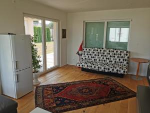 een woonkamer met een koelkast en een tapijt bij Schöne große 90 m² Ferienwohung in Zweikirchen 