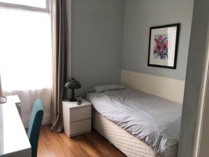 una piccola camera da letto con un letto e un comodino di Drumorne a Edimburgo