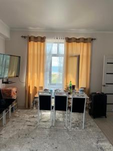 a room with a table with chairs and a window at Берег-4 in Bosteri