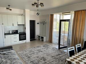 a kitchen with white cabinets and a table in a room at Берег-4 in Bosteri