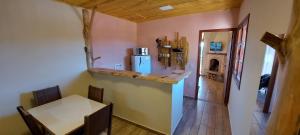 a dining room with a table and a refrigerator at Recanto das Glicínias in Monte Verde