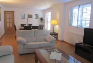 a living room with a white couch and a table at Villa for rent in Cullera Valencia in Cullera