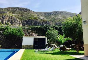 a backyard with a pool and chairs and a mountain at Villa for rent in Cullera Valencia in Cullera
