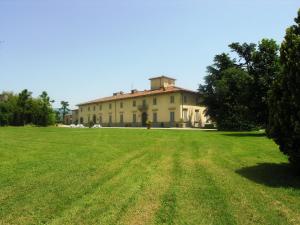 un gran edificio con un campo de césped delante de él en Villa Senni, en Scarperia