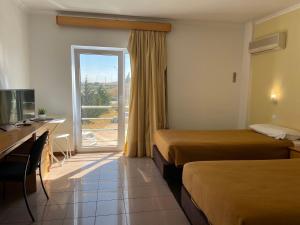 a hotel room with two beds and a desk and a window at Juiceven Studios in Alcabideche +40 photos