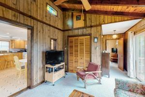 a living room with a television and a kitchen at AVHC23 Beach Box in Avon