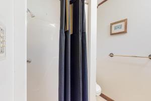 a shower curtain in a bathroom next to a toilet at AVHC23 Beach Box in Avon +19 photos