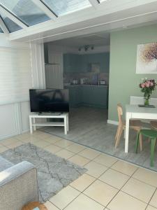 a living room with a couch and a table and a television at Lazy Acres Annex in Langtree