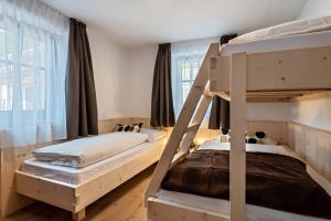 a bedroom with two bunk beds and a window at Sparberhof Apt Floriani in Campo di Trens
