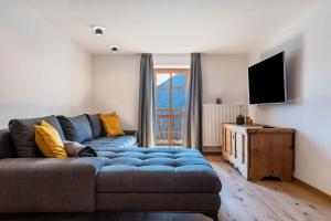 a living room with a blue couch and a television at Sparberhof Apt Floriani in Campo di Trens