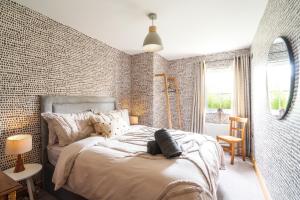 a bedroom with a bed and a brick wall at The Arches in Ballycastle