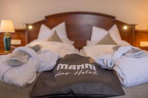 a bedroom with a bed with towels on it at MANNI das Hotel in Mayrhofen