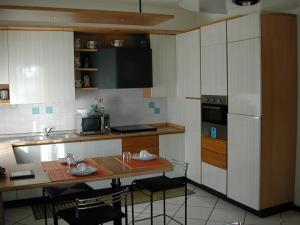 a small kitchen with a table and a refrigerator at Bed Ventitre in Padova