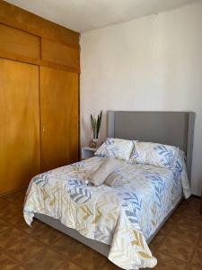 1 dormitorio con 1 cama grande y armario de madera en Casa Yolcatl en Ciudad de México
