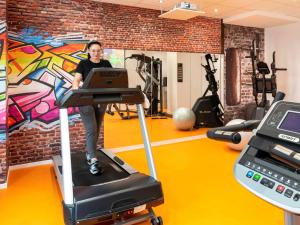 a woman on a treadmill in a gym at Mercure Trouville Sur Mer in Trouville-sur-Mer