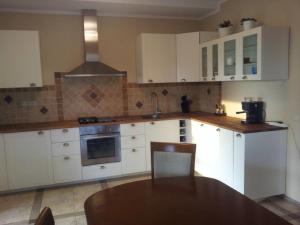 a kitchen with white cabinets and a table in it at Villa Cheval in Aukštadvaris