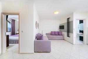 a living room with a purple couch and a bed at Maryan in Limenas