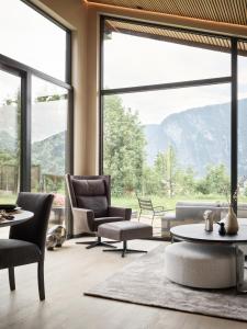 a living room with chairs and tables and large windows at Koie Deluxe in Stranda