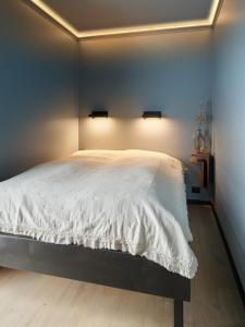 a bedroom with a large white bed with two lights at Koie Deluxe in Stranda