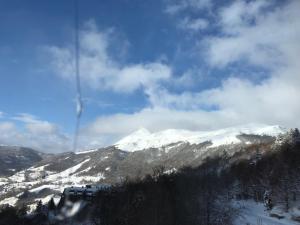 uma vista para uma montanha coberta de neve com um comboio em appartement 10 couchages le lioran bord rando/ski em Le Lioran