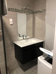 ein Badezimmer mit Waschbecken und Spiegel in der Unterkunft appartement 10 couchages le lioran bord rando/ski in Le Lioran