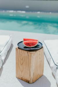 a slice of watermelon on a plate on a wooden stump at Kostantakis Pool house in Pollonia