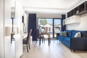 een woonkamer met een blauwe bank en een tafel bij Iron Apartments in Krakau