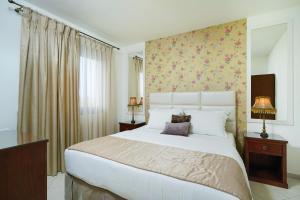 a bedroom with a large white bed with a floral wallpaper at Maryan in Limenas