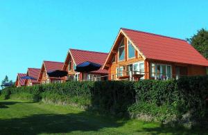 ein großes Holzhaus mit rotem Dach in der Unterkunft Feriepark Langeland Emmerbølle (Feriepark Langeland) in Emmerbølle