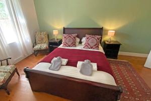 1 dormitorio con 1 cama grande con almohadas rojas en The Blue House, en Stanford