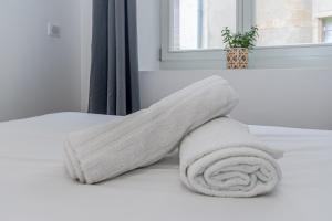 a white towel on a bed with a window at Appartement en centre piétonnier proche de la gare in Thionville