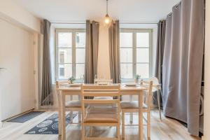 a dining room with a table and chairs and windows at Appartement en centre piétonnier proche de la gare in Thionville