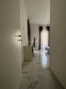 a hallway with a white room with a table and a door at Queens Jazz in Foggia