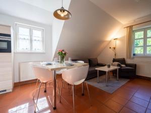 ein Wohnzimmer mit Tisch und Stühlen und einer Couch in der Unterkunft Feriendorf Rugana - Klassik Appartement mit 1 Schlafzimmer B21 in Dranske
