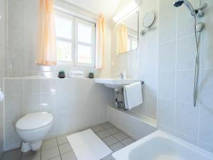 ein weißes Badezimmer mit Toilette und Waschbecken in der Unterkunft Feriendorf Rugana - Klassik Appartement mit 1 Schlafzimmer B21 in Dranske