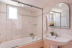 a bathroom with a tub and a sink and a shower at Azure Seaside Apts in Magnisía