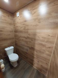 a bathroom with a toilet and a wooden wall at Домик с сауной для отдыха in Katase