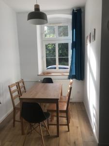stół i krzesła w pokoju z oknem w obiekcie Uroczy apartament w kurorcie w Kudowie Zdroju +3 zdjęcia