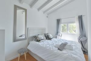 THE WHITE HOUSE BEAUSOLEIL- Monaco Border Waterfall & View of Sea and Monaco في بوسولاي: غرفة نوم بيضاء مع سرير أبيض كبير ونافذة