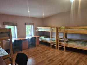 a room with three bunk beds and a desk at Liela Guest Apartament in Liepāja