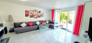 a living room with a couch and a table at MAISON APPARTEMENT TOUT CONFORT À 10mn des plages in Montpellier