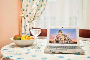 a laptop on a table with a bowl of fruit and a glass of wine at ❀ AURORA-AN OASIS IN VIBRANT DOWNTOWN! ❀ A/C, LIFT in Sofia