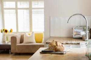 a kitchen with a couch and a table with bread at The Cheesery in Chinley