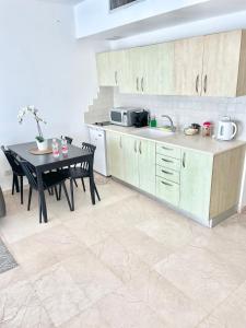 uma cozinha com uma mesa, um lavatório e um balcão em Oceanus apartment hotel em Herzeliya