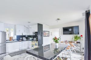 a kitchen with white cabinets and a black counter top at BIRDS EYE VILLA Luxury Castle Paranomic Views of Monaco Monte Carlo Hills & Sea in La Turbie